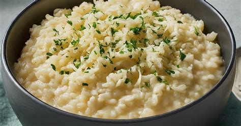 Plato de arroz cremoso con queso fundido y hierbas frescas