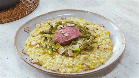 Imagen de un risotto de espárragos cremoso y bien presentado, con puntas de espárragos decorando la parte superior.