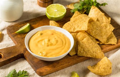 salsa de queso cremosa en un tazón con nachos