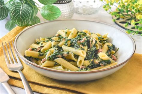 Plato de pasta con espinacas y salsa de tomate recién hecho