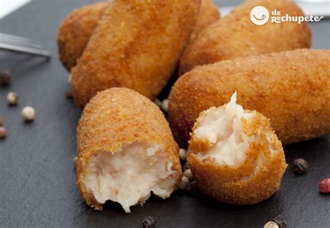 Infografía con los pasos clave para hacer croquetas de salmón caseras: preparación de la bechamel, formado, rebozado y fritura.