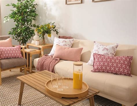 Sala de estar con sofá burdeos y cojines en tonos rosa empolvado o beige