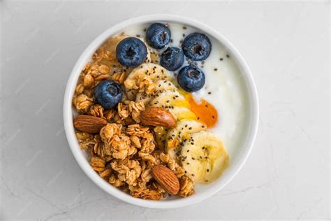 Tazón de yogur griego con kiwi en rodajas y frutos secos variados