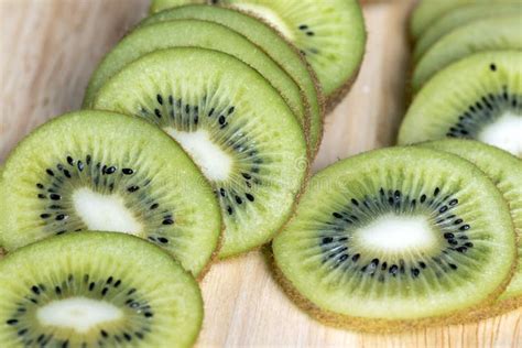 Kiwi entero y en rodajas sobre una tabla de madera