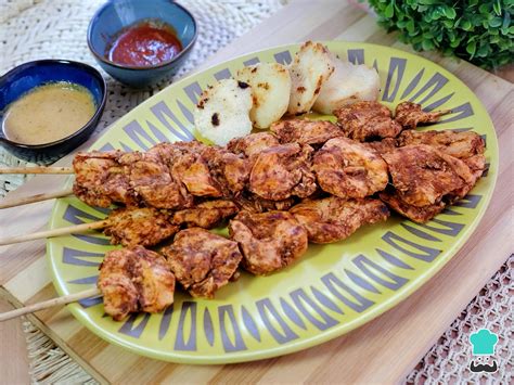 Plato de anticuchos de pollo con papas y salsas