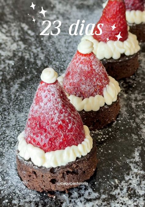cupcakes de chocolate con decoración de gorritos de Papá Noel usando fresas y crema batida