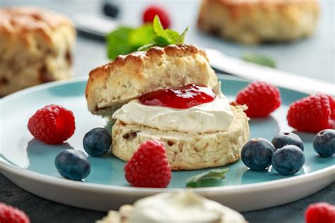 Plato de scones de yogur con mermelada y crema
