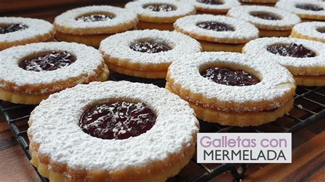 Varias galletas de mantequilla rellenas de mermelada de diferentes sabores y colores.