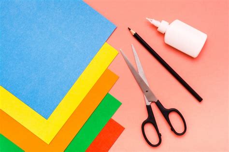 Variedad de materiales para manualidades: cartulinas de colores, tijeras, pegamento, regla y lápiz.