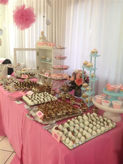 Mesa de postres decorada con tonos azules, detalles temáticos infantiles y arreglos de dulces variados