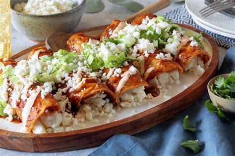 Foto de un plato de enchiladas rojas de queso horneadas, con queso gratinado y un poco de crema.