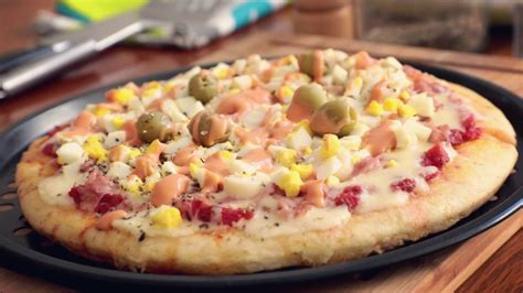 Pizza recién hecha con palmitos, salsa golf y jamón