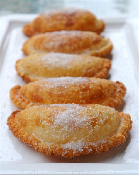 Fotografía apetitosa de empanadas de viento ecuatorianas recién fritas y espolvoreadas con azúcar