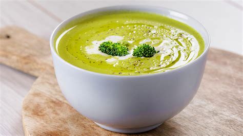 Plato de crema verde de brócoli y espinacas decorado con hierbas frescas