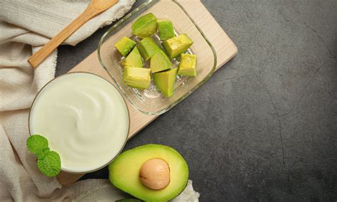 Foto de una salsa de yogur y palta y otra de mayonesa de cebollines, servidas con pinzas de jaiba