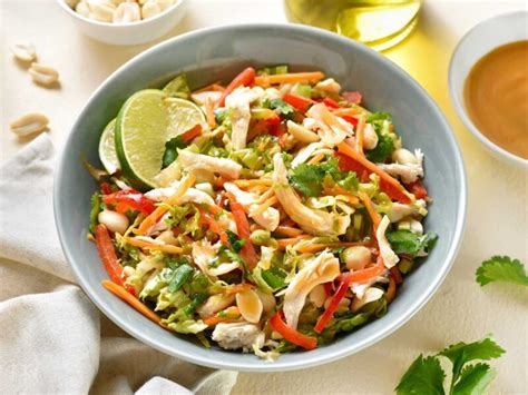 Ensalada tailandesa de pollo y fresas servida en un bol, destacando la mezcla de colores vibrantes y texturas variadas.