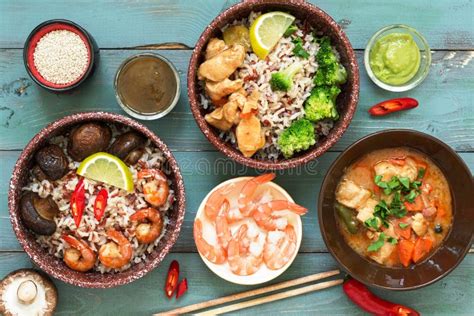 Variedad de platos asiáticos coloridos en cuencos y en un wok