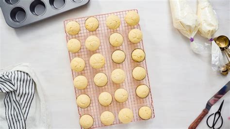 Bandeja con cupcakes de vainilla recién horneados en cápsulas de papel.