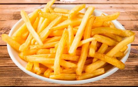Imagen de patatas fritas doradas y crujientes recién hechas en una freidora de aire.