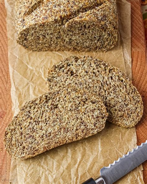 Fotografía cenital de un sándwich artesanal de pan de linaza con salmón marinado y vegetales frescos