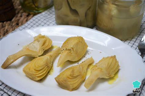 Ingredientes frescos para preparar alcachofas en conserva: alcachofas, limones, vinagre, sal y especias