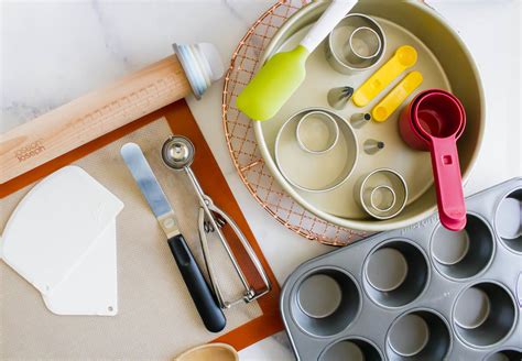 Mesa con utensilios de cocina para repostería, incluyendo un molde de tarta, batidora y limones