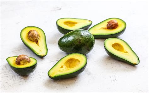 Bol de almendras y aguacates cortados en una tabla