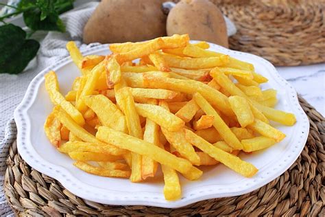Papas fritas caseras horneadas en una bandeja con hierbas