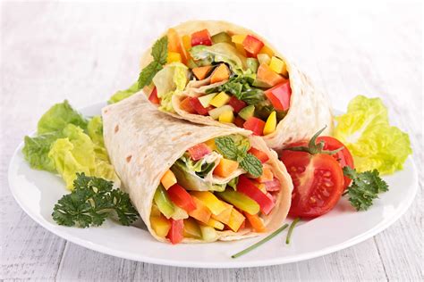 Variedad de wraps vegetarianos con diferentes colores y texturas de vegetales, aguacate, tofu y salsas