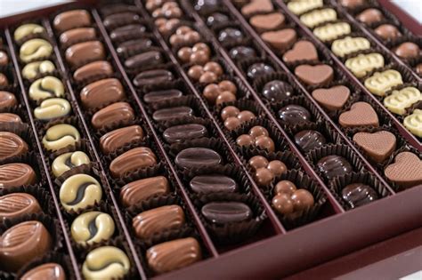 Foto de una caja de bombones de chocolate variados, con algunos de ellos mostrando ligeras imperfecciones estéticas pero luciendo deliciosos