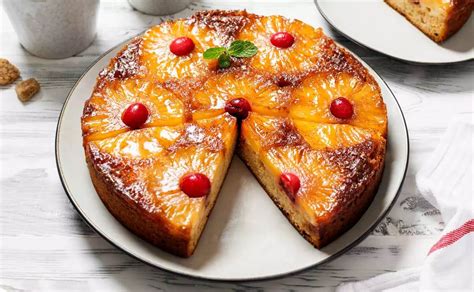 Fotografía profesional de un pastel de piña invertido terminado con rodajas de piña y guindas sobre una base caramelizada