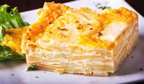 Fotografía profesional del pastel de papa arequipeño recién salido del horno con una textura dorada y crujiente