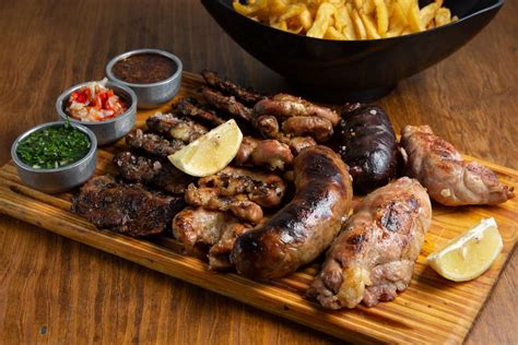 Fotografía profesional de una parrillada completa servida en mesa con cortes de carne y embutidos