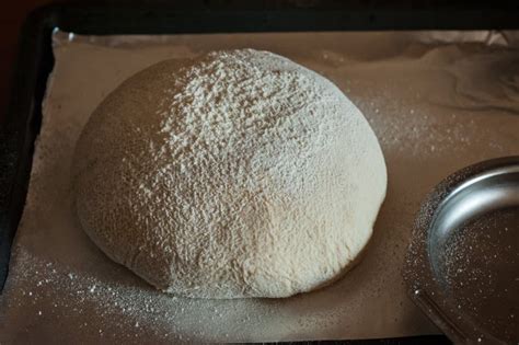 Masa de pan rústico en proceso de levado, mostrando su textura burbujeante y esponjosa.