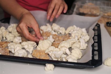 Foto de una persona preparando coliflor en la cocina
