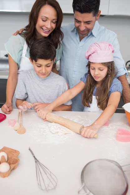 Familia preparando galletas en la cocina, con niños divirtiéndose