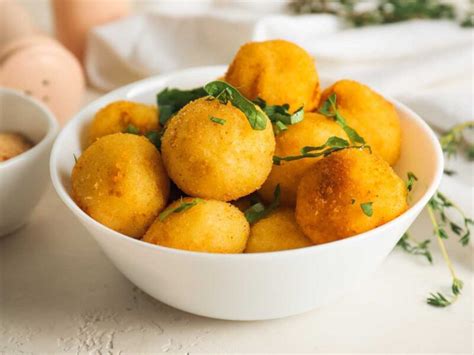 Niño cocinando patatas cocidas con ayuda de un adulto