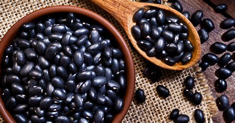 Plato servido de porotos negros con pernil, arroz y longaniza frita