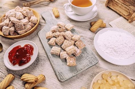 Foto de varias galletas árabes variadas en un plato, algunas espolvoreadas con azúcar glas, otras con sésamo o frutos secos.