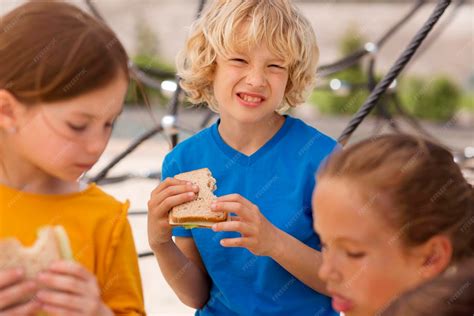 niños comiendo sándwiches con entusiasmo