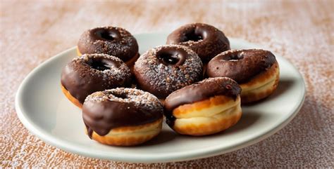 Plato con donas caseras de piña, algunas rellenas de chocolate y otras con rodajas de piña