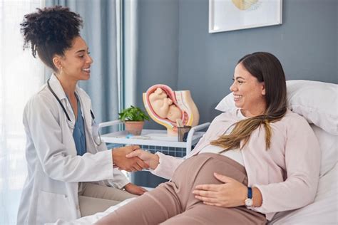 Médico ginecólogo y paciente embarazada conversando sobre prácticas de bienestar