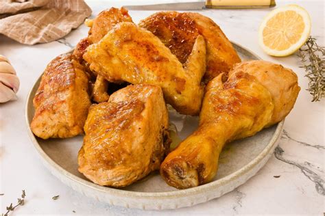 Plato de trozos de pollo dorado en una sartén