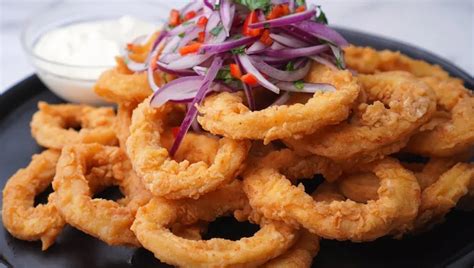 Chicharrón de calamar dorado y crujiente, servido con salsa tártara y limón