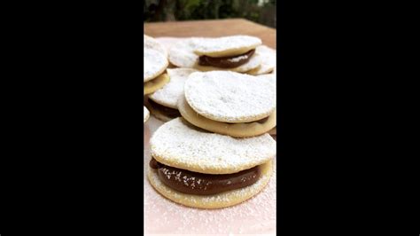 Foto detallada de chilenitos rellenos de manjar espolvoreados con azúcar flor.