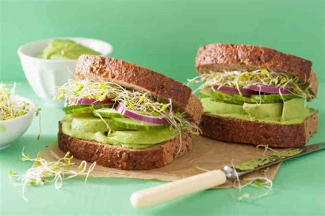 Foto de un apetitoso sándwich vegetariano de lentejas, con capas de ingredientes frescos y una hamburguesa de lentejas dorada.