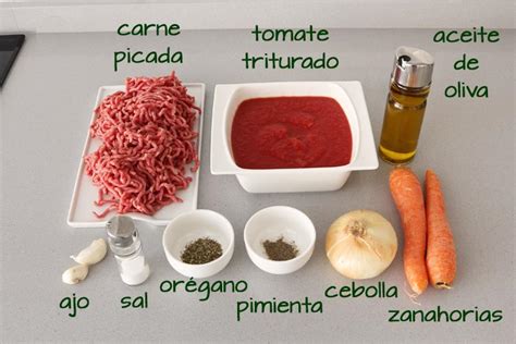 Mesa con ingredientes frescos para salsa boloñesa (verduras, carne, tomate, pasta)