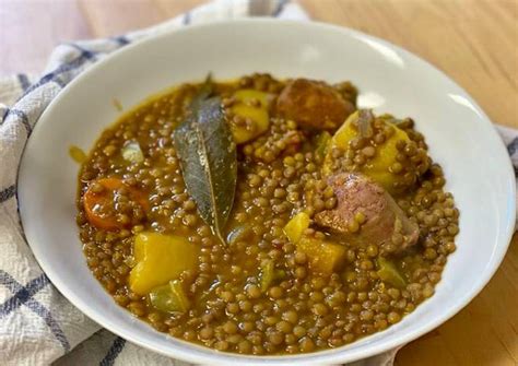 Primer plano de un bol de lentejas estofadas con chorizo y verduras, listo para servir