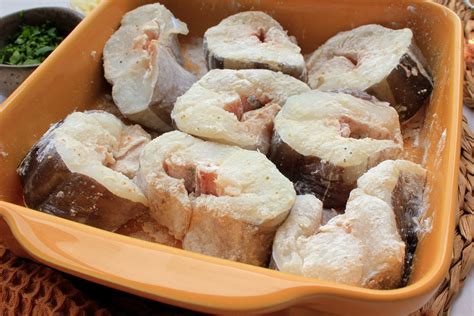 Fotografía del congrio horneándose en la fuente con cebolla y mantequilla.