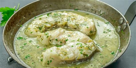 Imagen de una copa de vino blanco junto a un plato de congrio en salsa margarita.